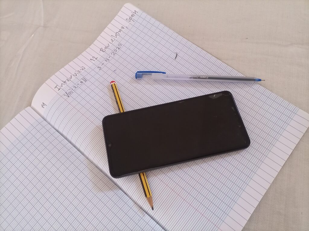 Notebook with pencil, pen, and phone